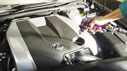 施工中:スプレーガンでエンジンルームに塗布している様子