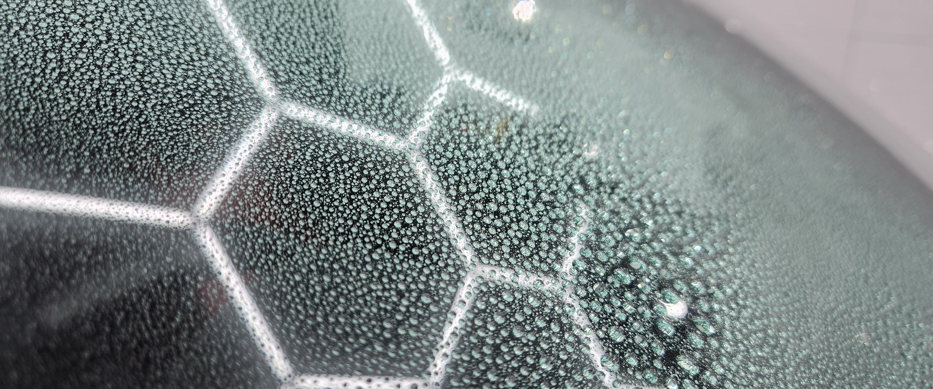 雨天のフロントガラスに水滴が丸く弾いている様子(車内から外を見た構図でも可・横1920px)