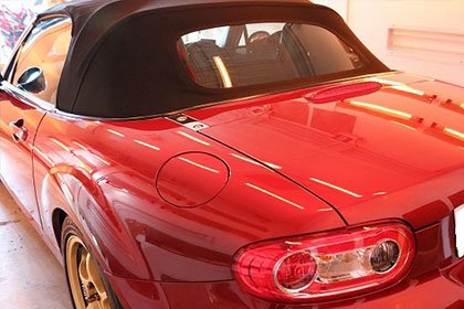 オープンカーの幌(ソフトトップ)を閉じた状態の斜め後方からの写真。水滴が布地の上で玉になっていると理想的(横1920px)