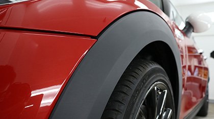 未塗装樹脂パーツ(フェンダーアーチやバンパー下部)のアップ。左右で施工前後の差が分かる構図が理想(横1920px)